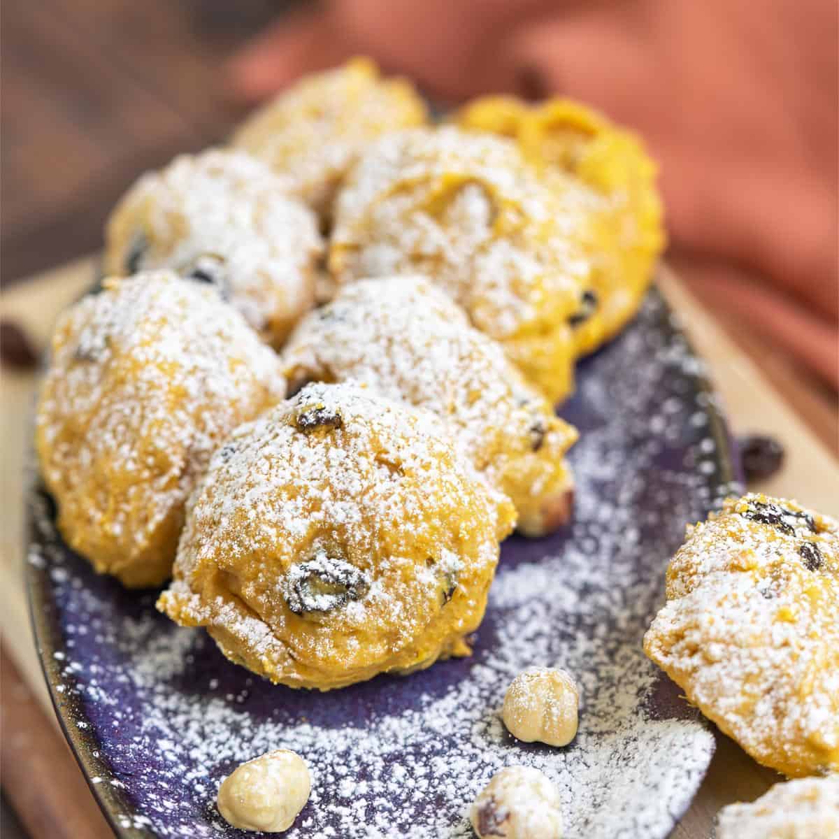 Hazelnut Pumpkin Orange Cookies closeup on a plate and dusted with powdered sugar.