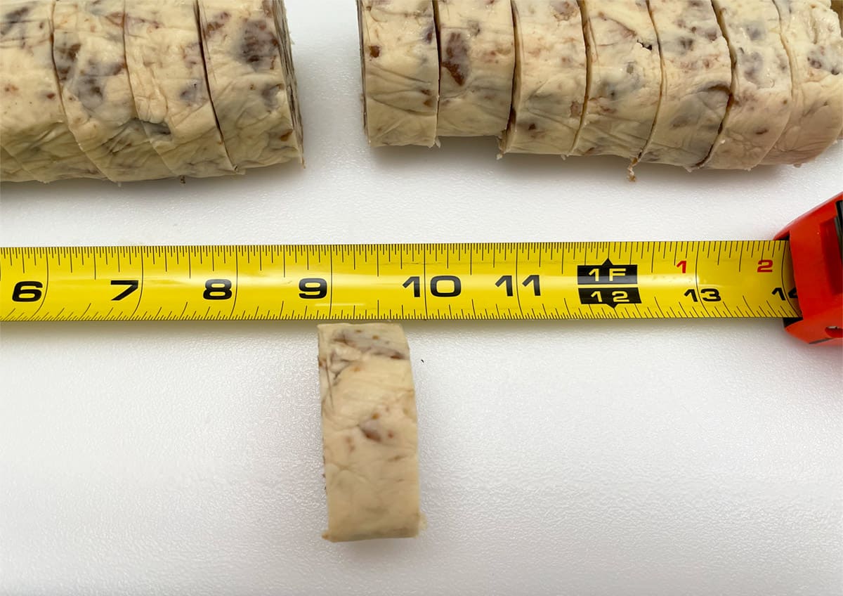 Measuring tape showing width of sliced cookies from a cookie log.