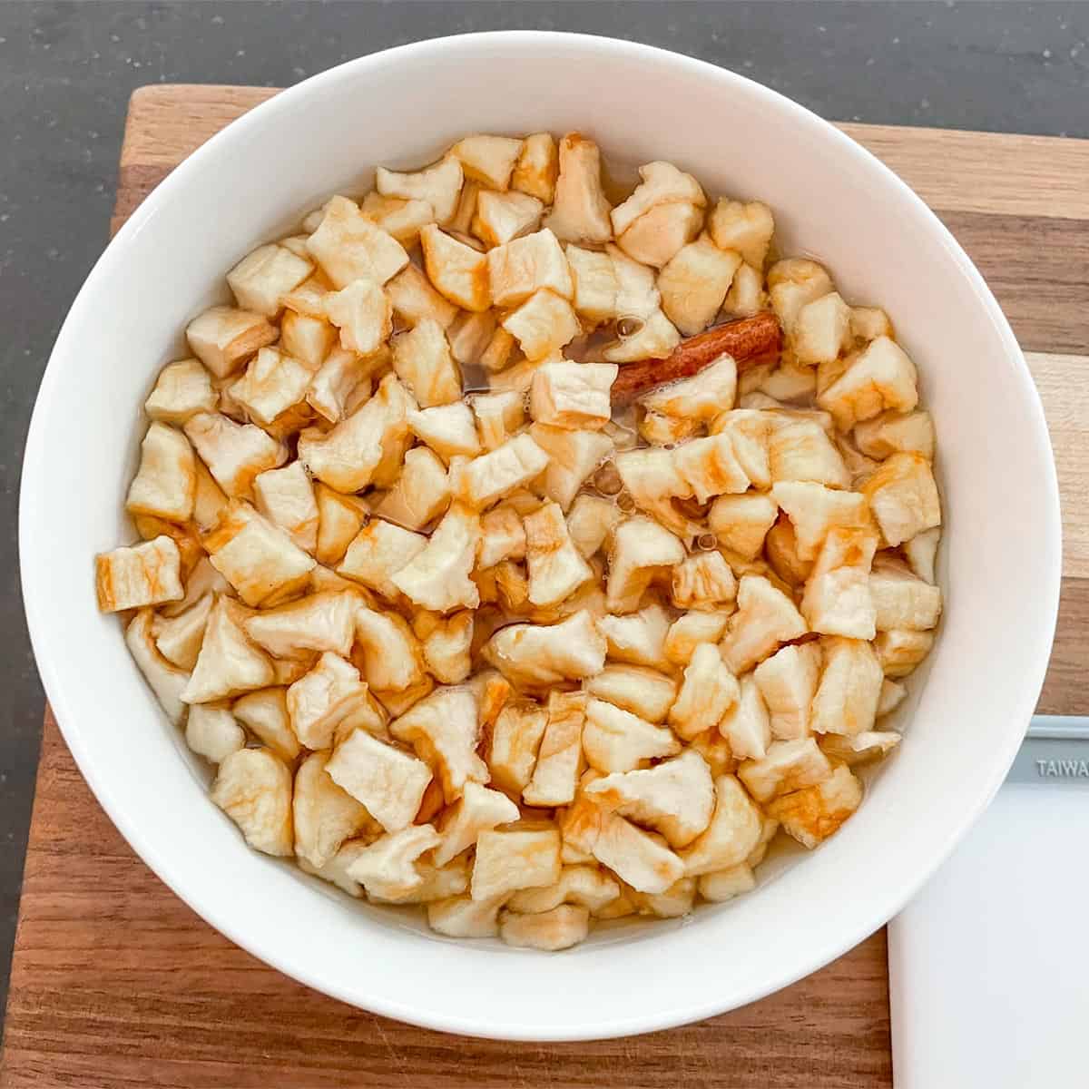 Dried apple pieces soaking in the hot apple juice with cinnamon liquid.