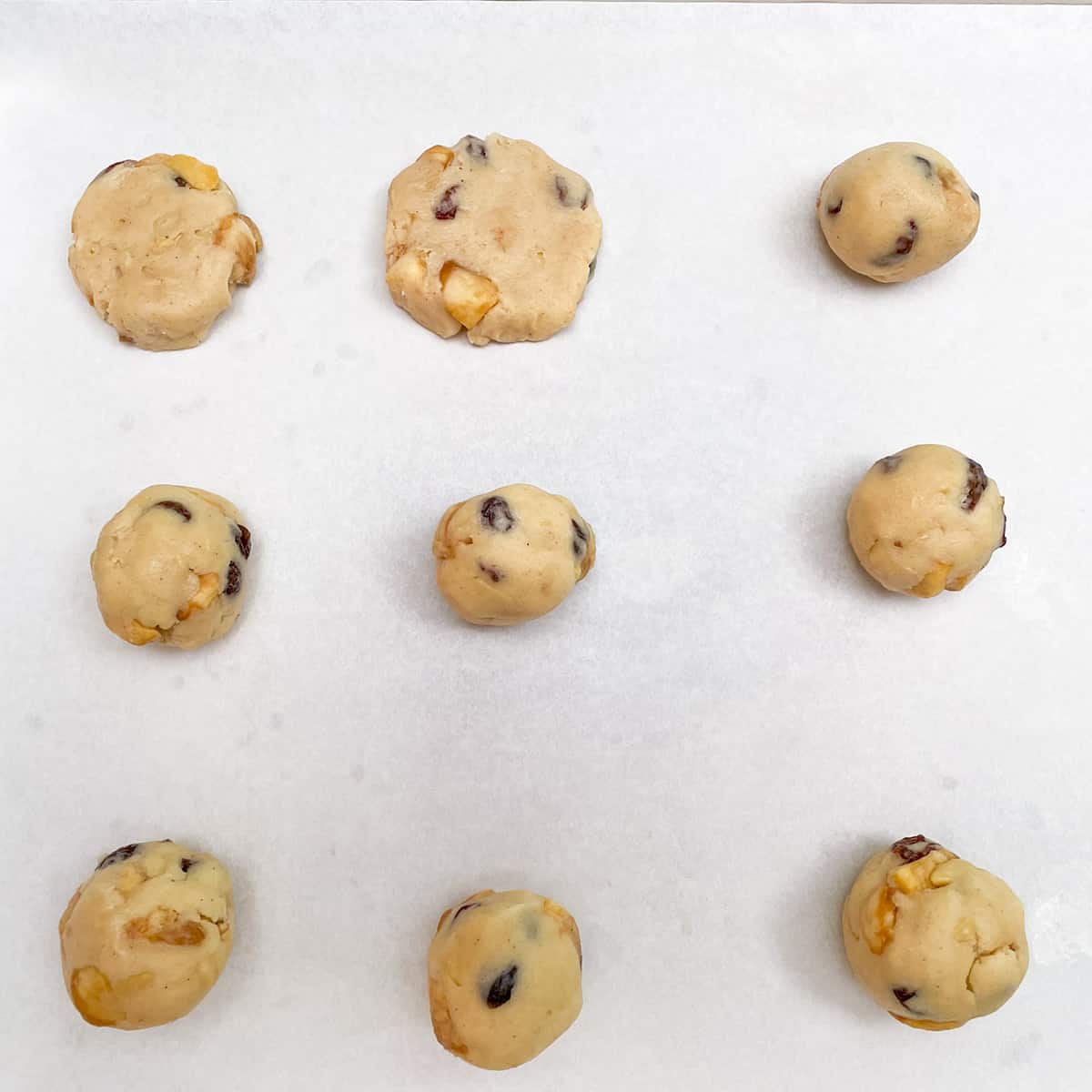 Showing nine cookie balls where two of them have been flattened.