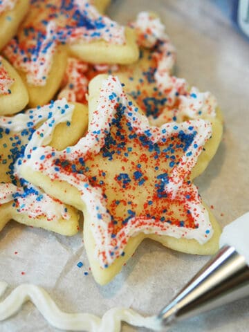 4th of July, star cookies with white piping around the edges and red and blue sprinkles.