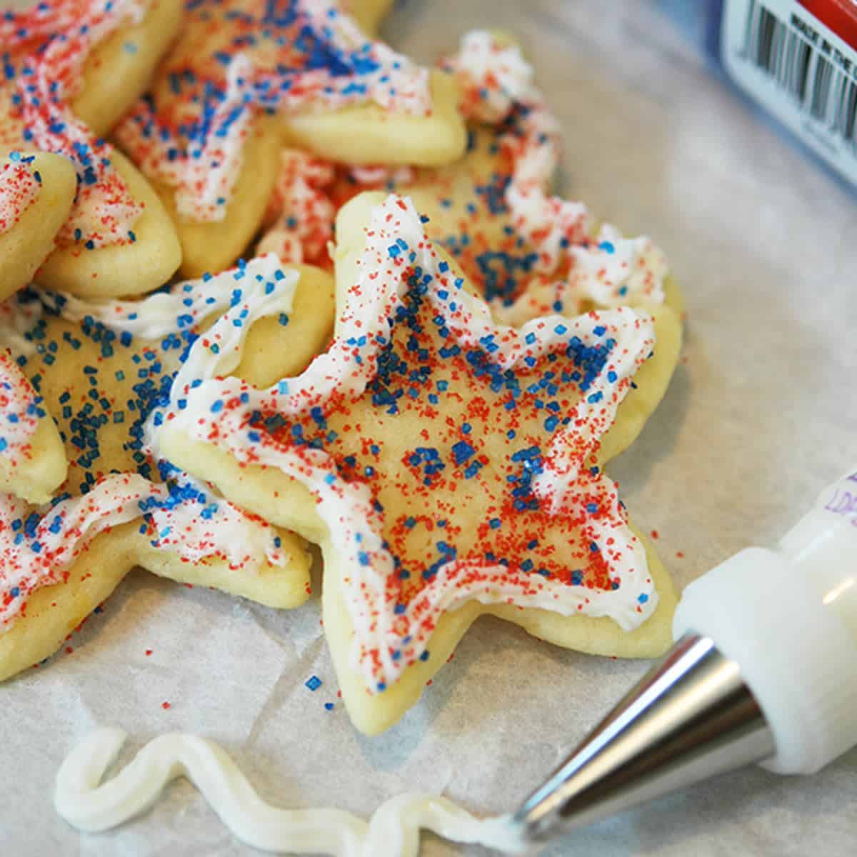 4th of July, star cookies with white piping around the edges and red and blue sprinkles.