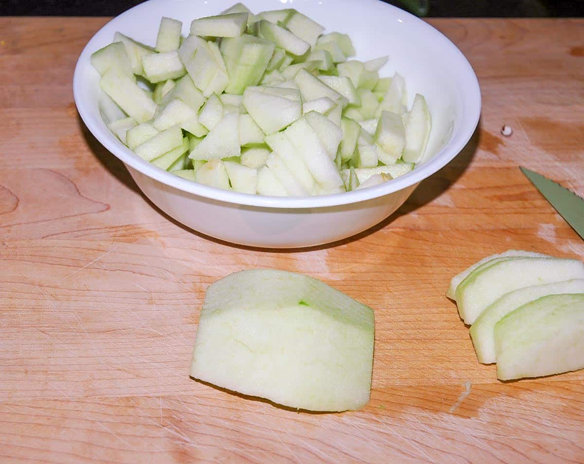 Cutting up a green Granny Smith apple on a wood cutting board.