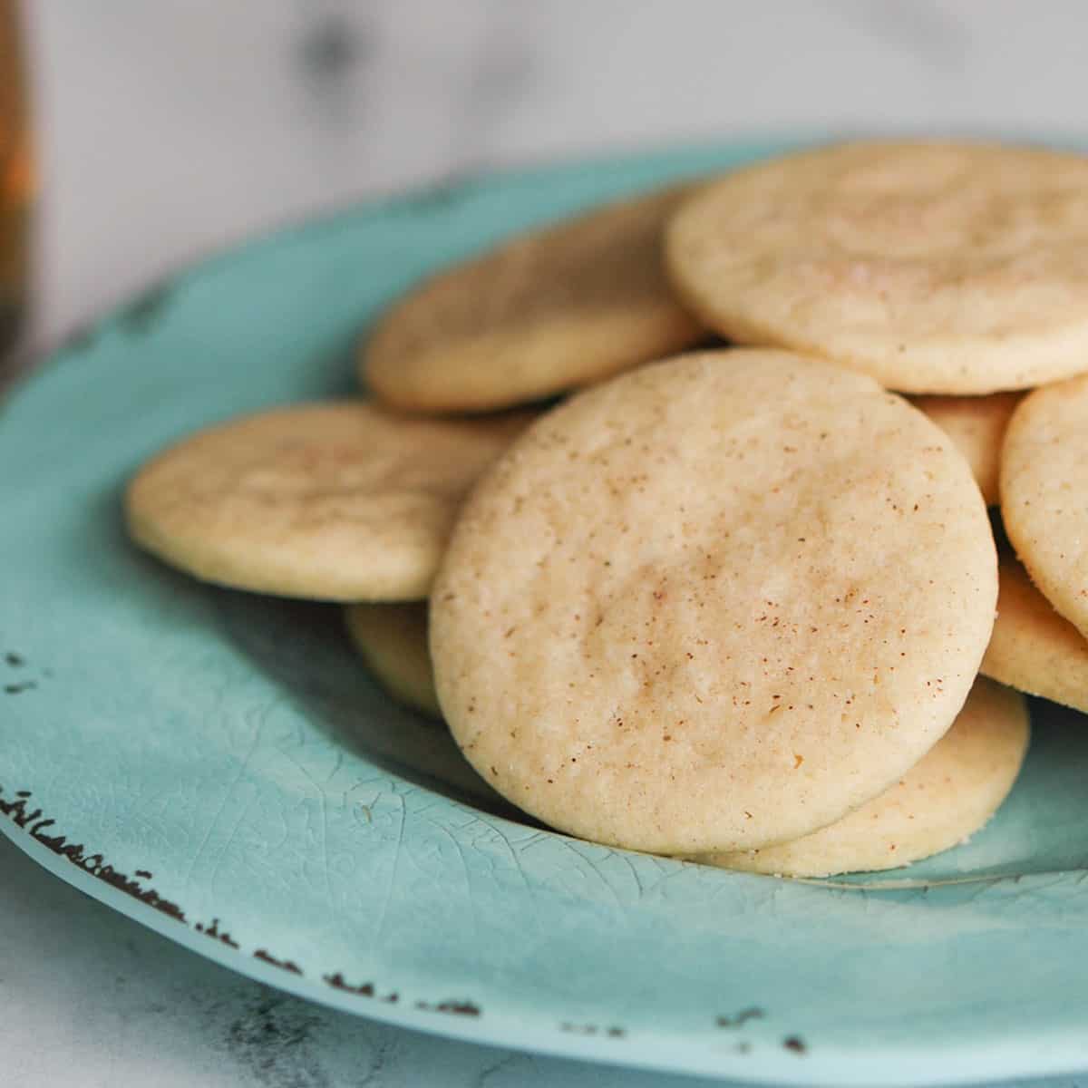 A pile of apple cinnamon sugar cookies on a green plate.