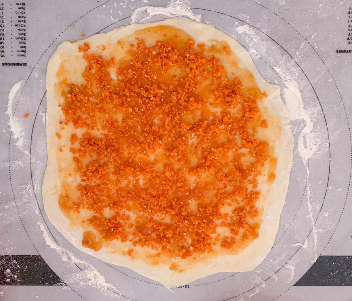 Dried apricots and almond mixture is spread on top of the apricot preserves.