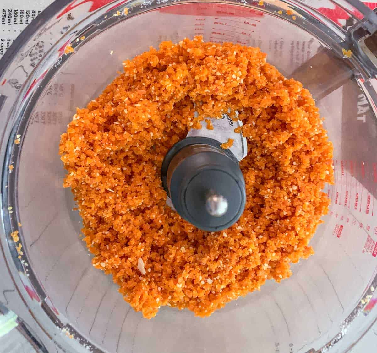 In a food processer, the dried apricots and almonds are pulsed till crumbly.