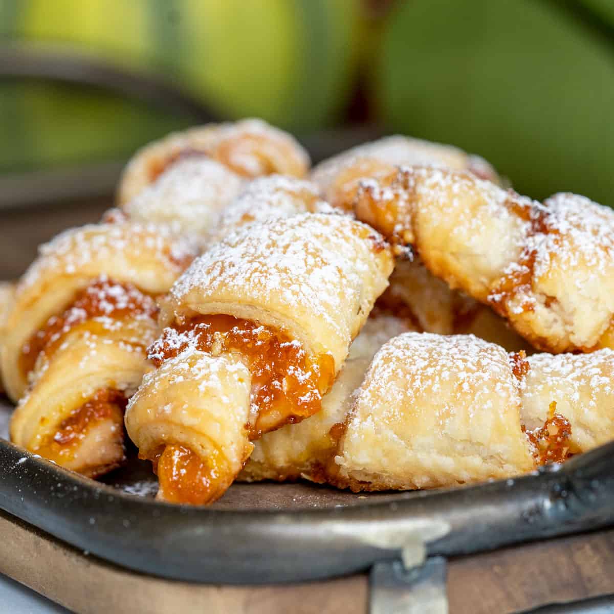 Apricot Almond Rugelach cookies on a wooden tray.