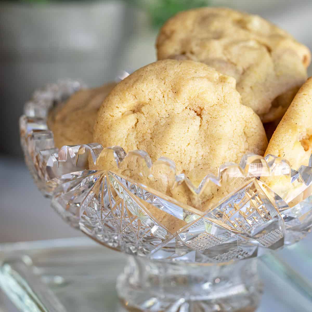 Caramel Pear with almond cookies in a cut-glass bowl.