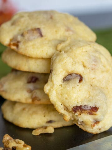 Stack of golden-colored cookies with dates and walnuts showing.