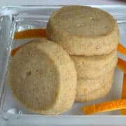 Stack of Cardamom Orange shortbread cookies with slices of orange skin.