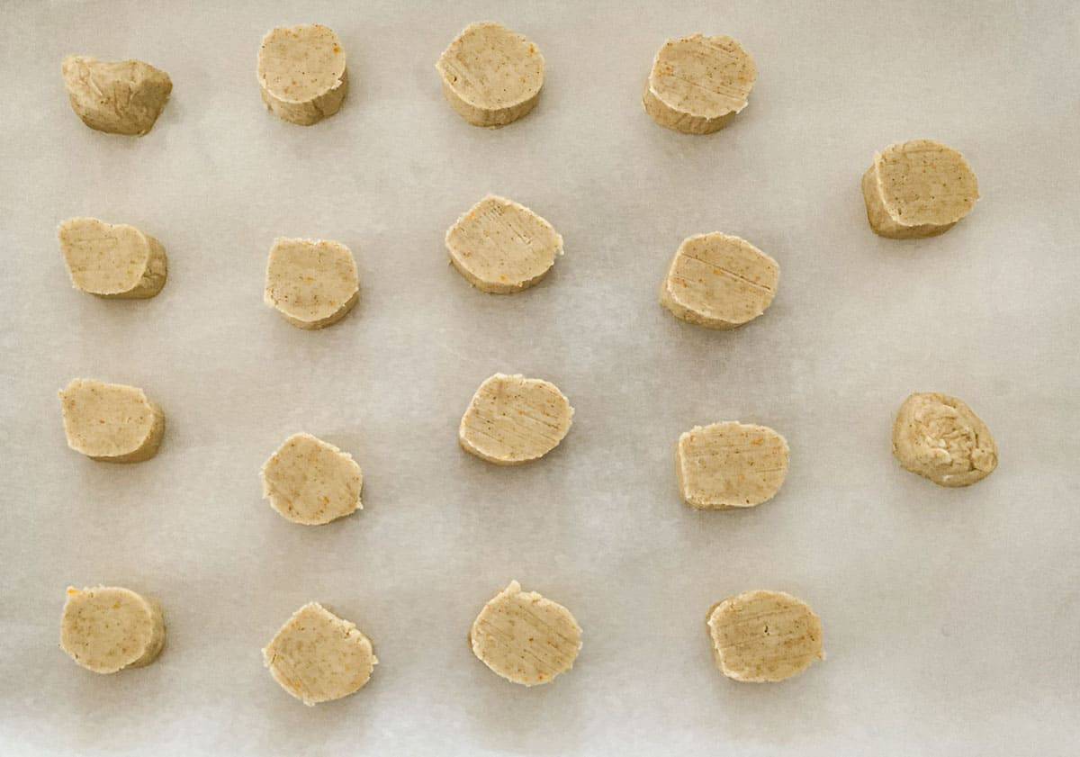 Sliced shortbread logs and placed on parchment paper.