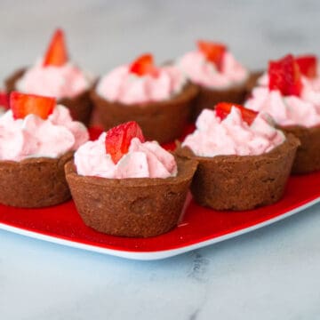 Chocolate cookie cups filled with strawberry whipped cream.