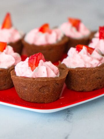 Chocolate cookie cups filled with strawberry whipped cream.