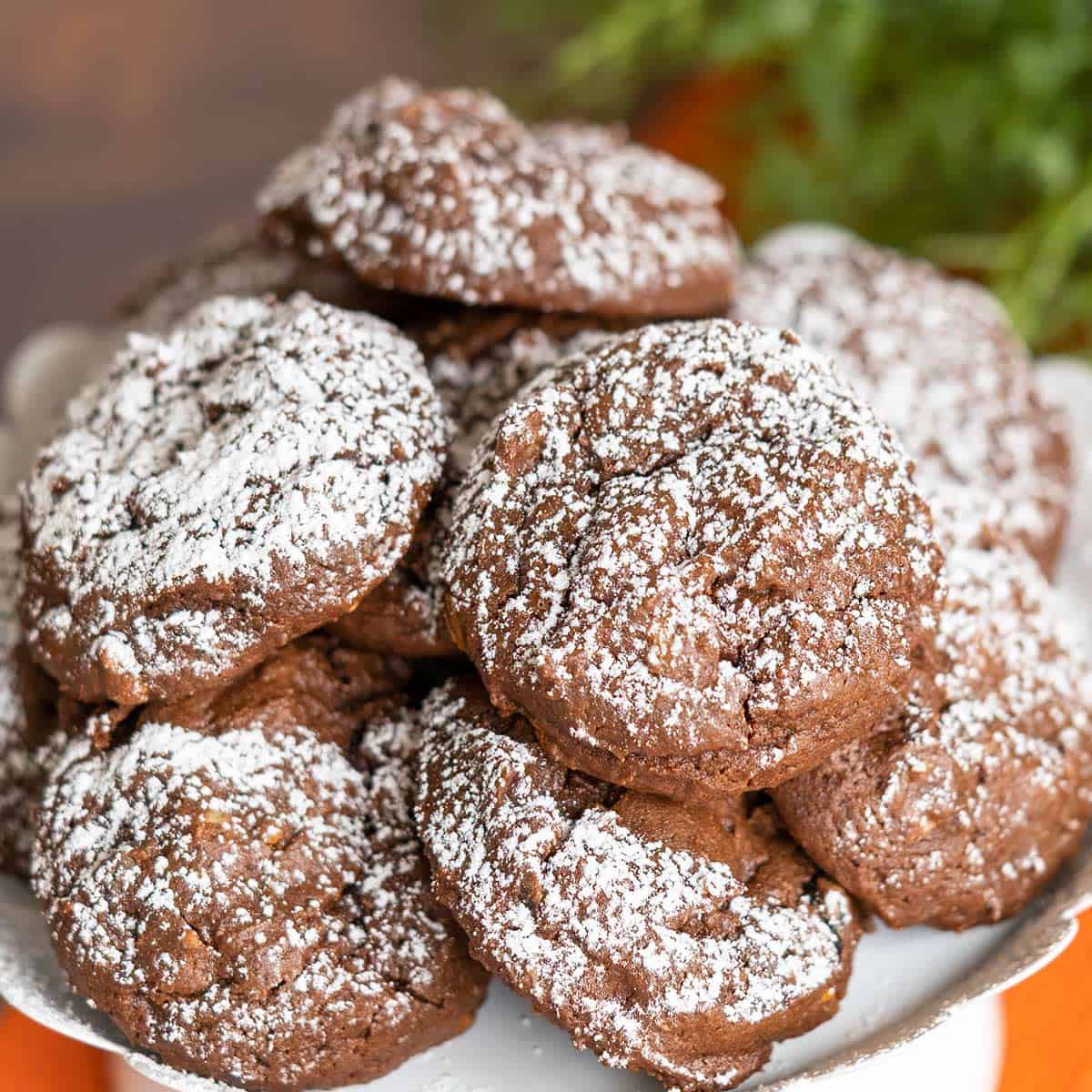 Chocolate Hazelnut Cookies with Espresso Chips cookies on a white plate with powdered sugar on top.