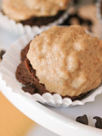 Chocolate with peanut butter cupcake cookies in a small cupcake wrapper on a white dish.