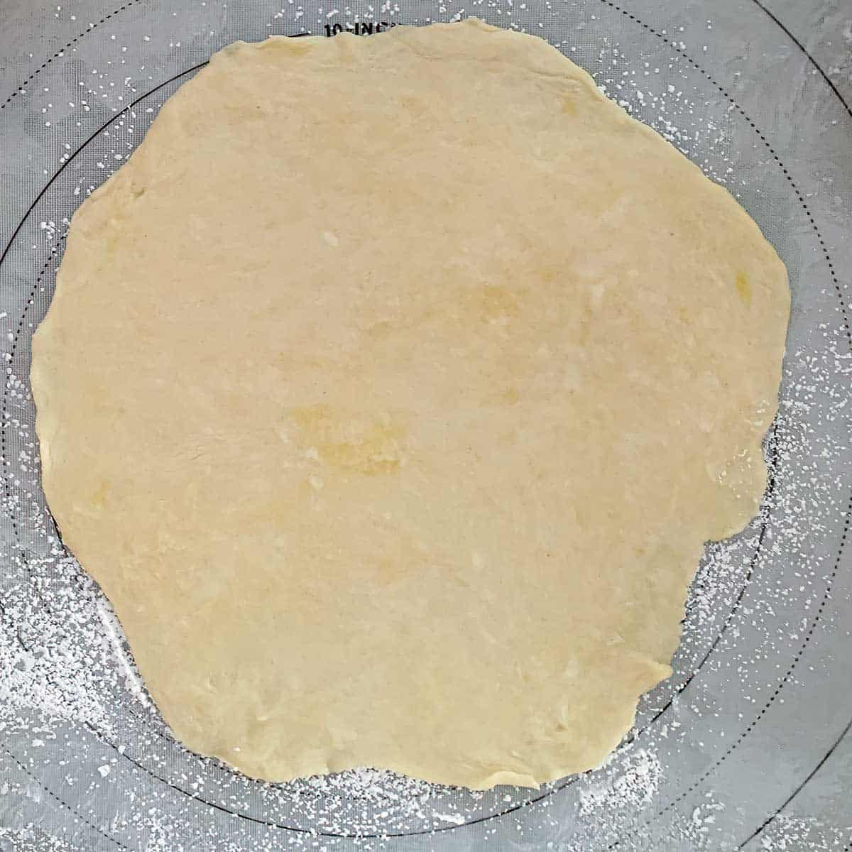 Cookie dough rolled out on pastry mat.