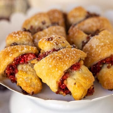 A display of Cranberry Orange and Walnut Rugelach on a white stand.