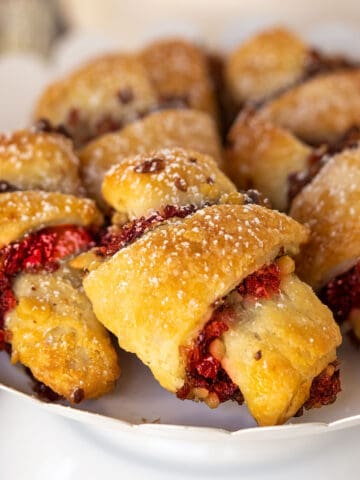 A display of Cranberry Orange and Walnut Rugelach on a white stand.