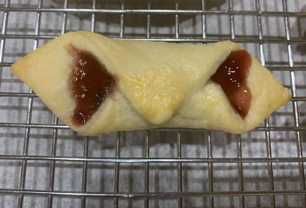 Finished single red raspberry Kolache on a cooling rack.