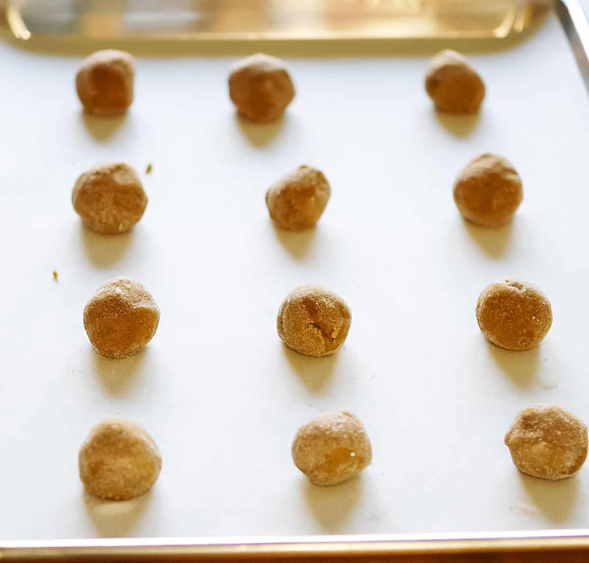 So good ginger cookie dough rolled in sugar and placed on a cookie sheet pan.