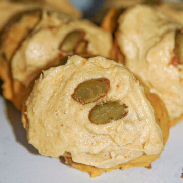 This is a pumpkin cookie with pumpkin icing and candied pumpkin seeds on top.