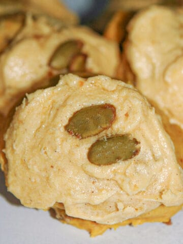 This is a pumpkin cookie with pumpkin icing and candied pumpkin seeds on top.