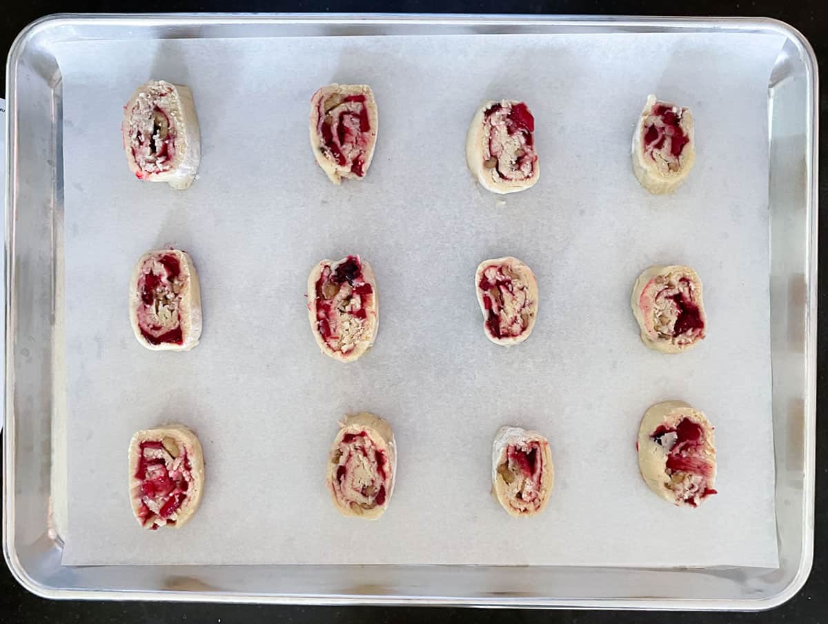 Apple Cranberry Walnut Swirl dough was sliced from the roll and placed on parchment paper on a cookie sheet pan.