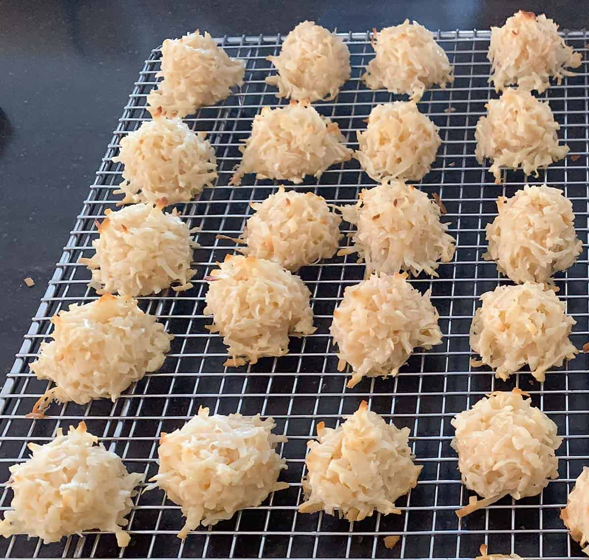Coconut macaroons baked and cooling on a wire rack.