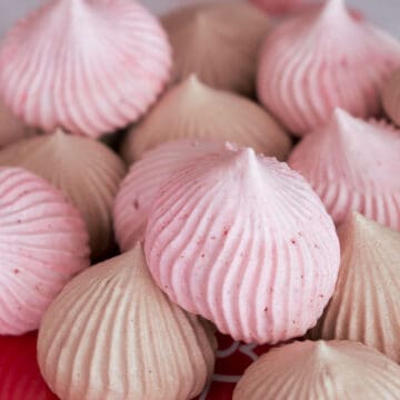 Strawberry and Chocolate Meringue Cookies on a red plate.