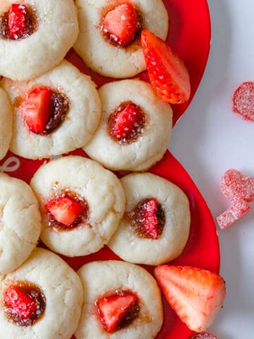 Thumbprint cookies with strawberry jam and a piece of fresh strawberry.