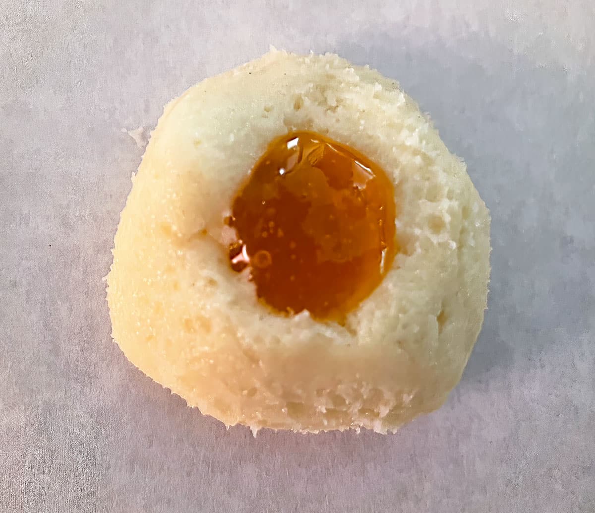 Single thumbprint cookie with jam waiting for the oven.