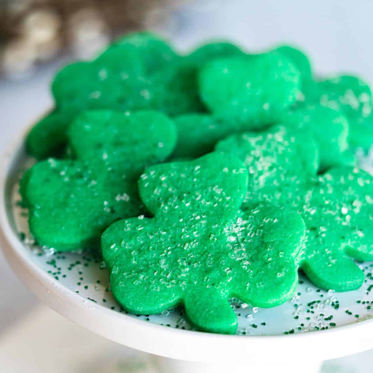 Ready to eat shamrock cookies on a white serving dish.