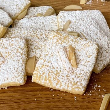 Italian Almond with Lemon cookies sitting on a wooden serving tray.