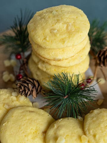 Lemon with a touch of Honey Cookies stacked with pine cone and pine branches around the base of cookies.