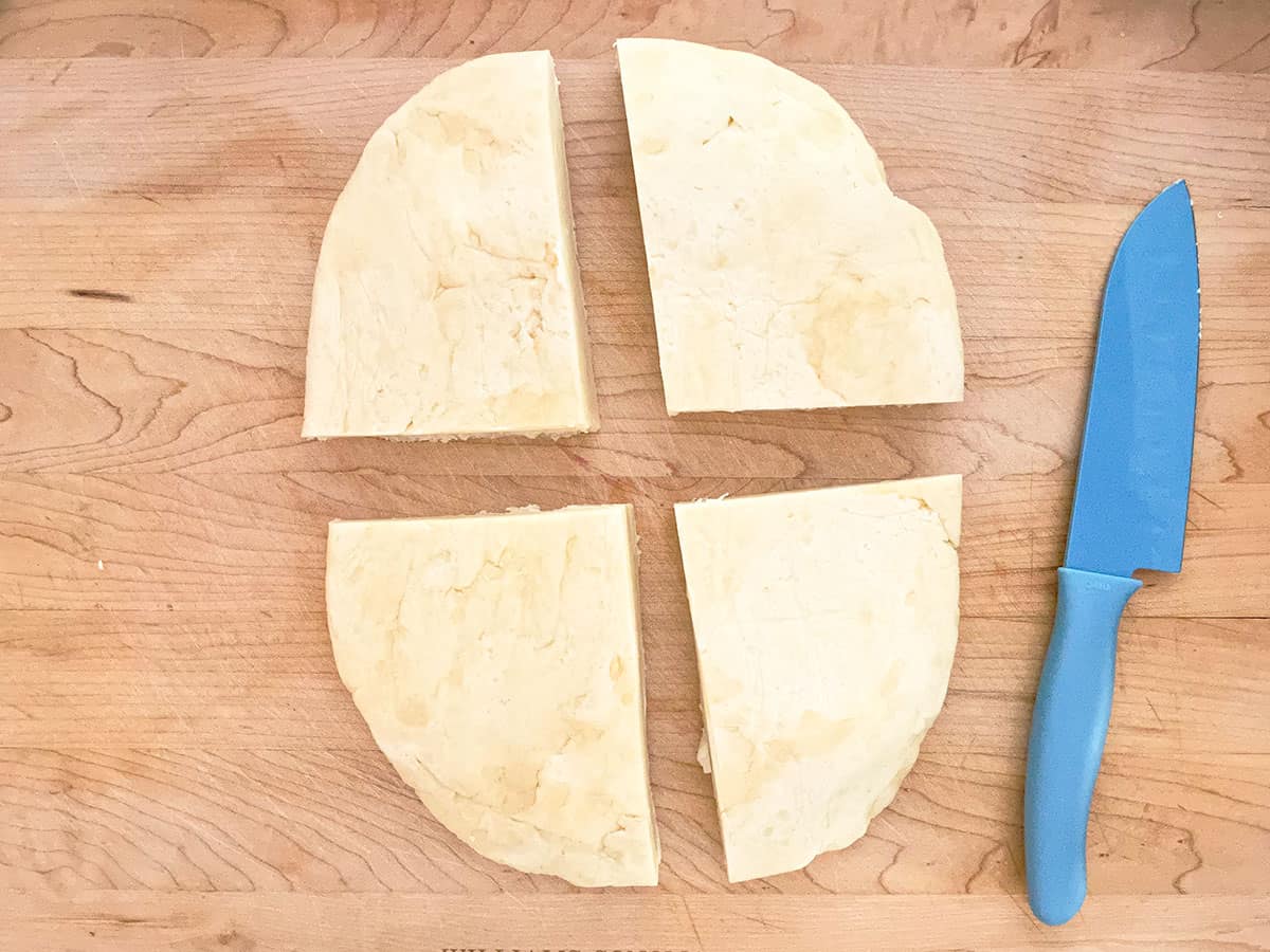 Flat oval cookie dough cut into quarters.