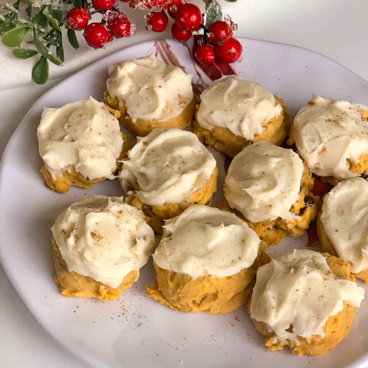 Pumpkin Cranberry Cookies and Cream Cheese Icing on a white plate with a sprig of mistletoe.
