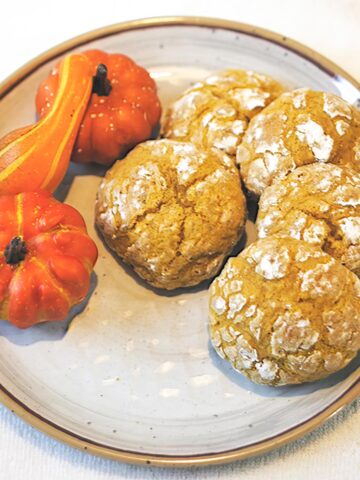Soft Pumpkin Cookies on a plate with a few small pumpkins.