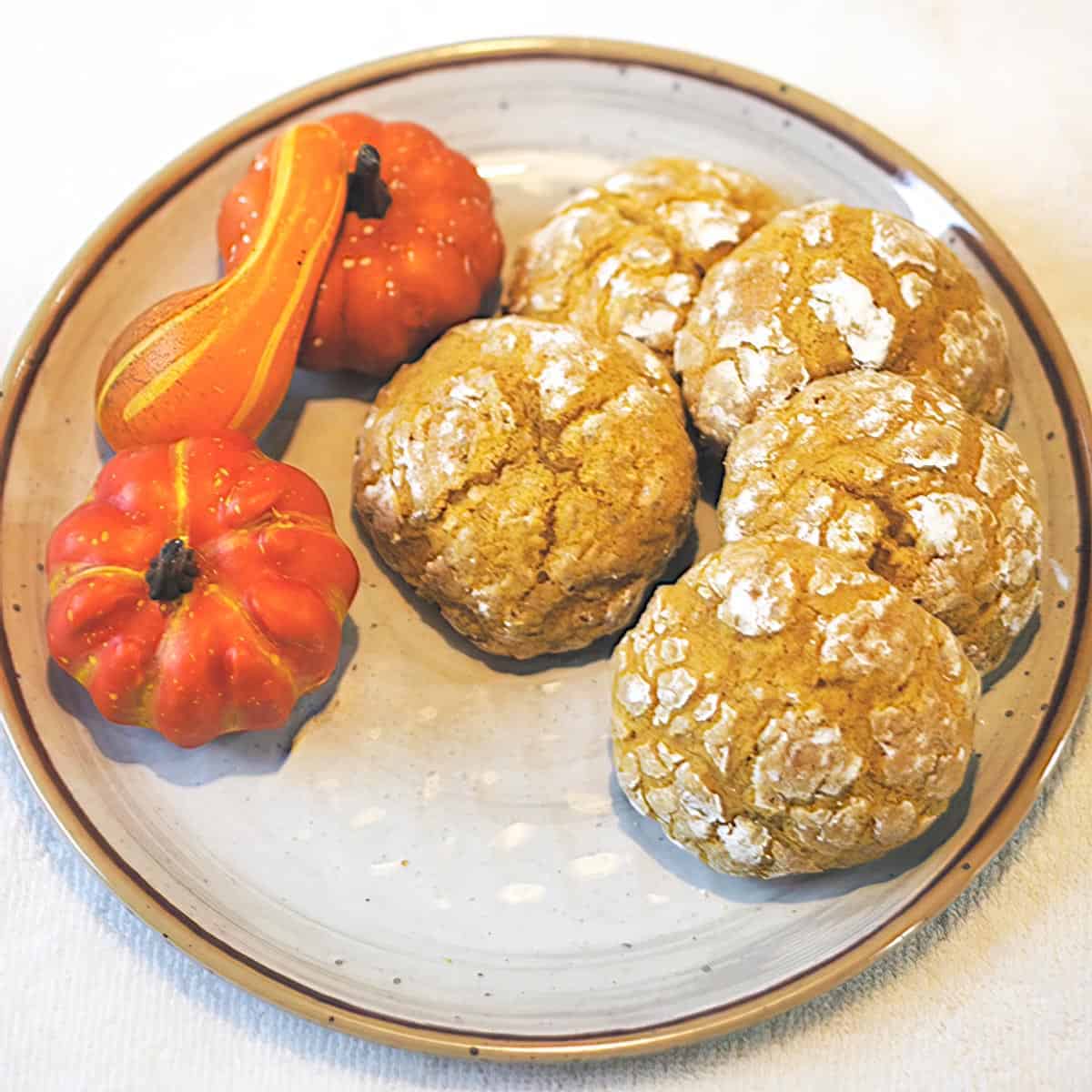 Soft Pumpkin Cookies on a plate with a few small pumpkins.