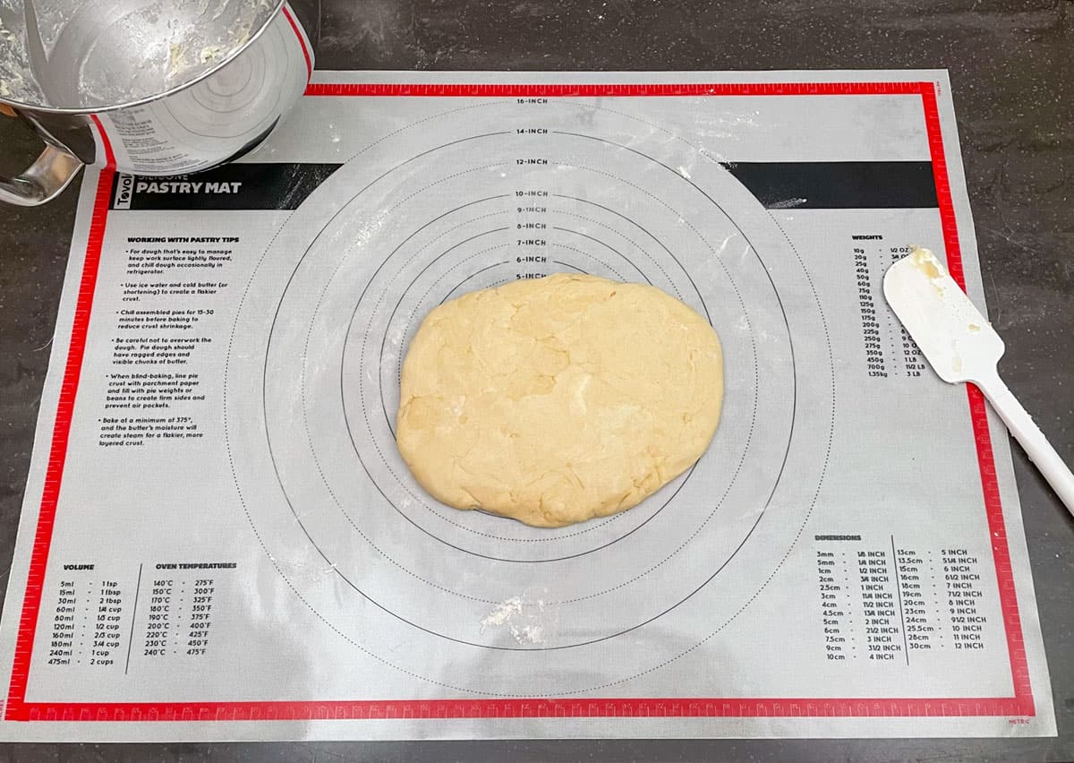 Cookie dough mixed and add to a pastry mat so the dough can be pressed into an oval flat shape.