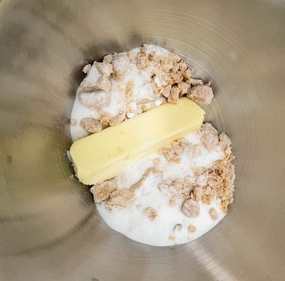 Butter, white sugar and light brown sugar getting ready to be mixed.