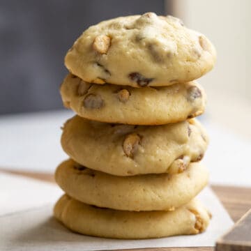 A stack of caramel and cinnamon with pecan cookies on a wooden plank.