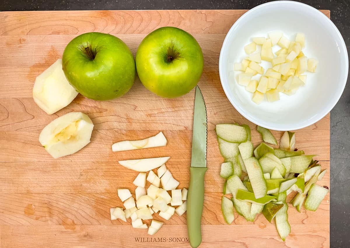 Cutting up Granny smith apples into bite size pieces.