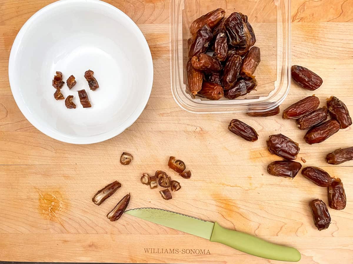 Cutting up pitted dates into small pieces.