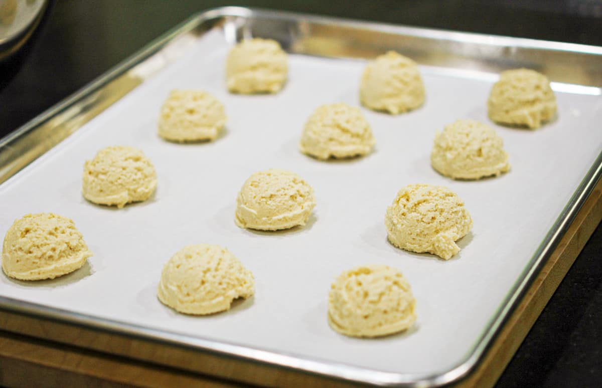 Amish sugar cookies scooped out onto a cookie sheet pan.