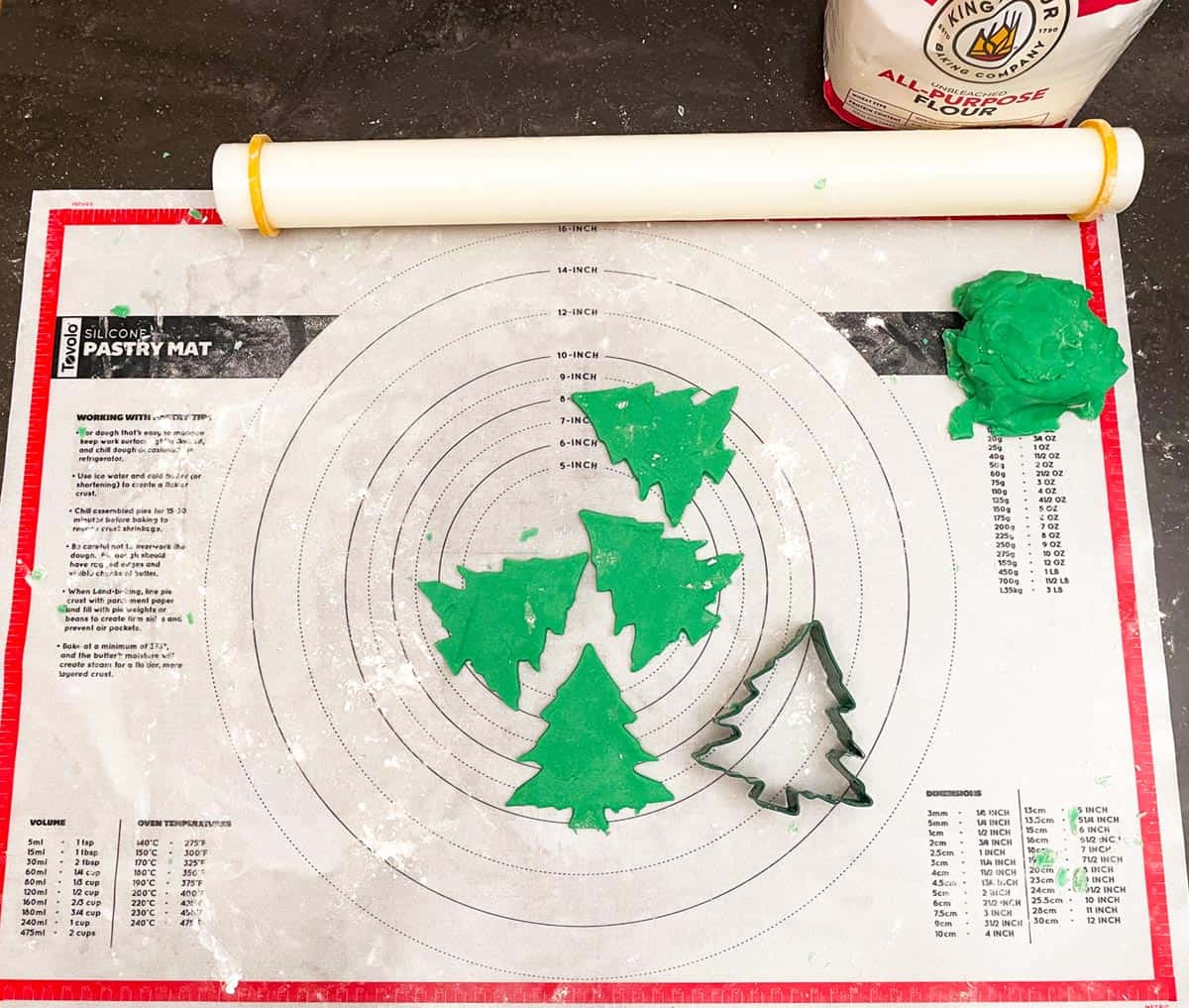 Christmas tree sugar cookie dough rolled and cut out into Christmas tree shapes.