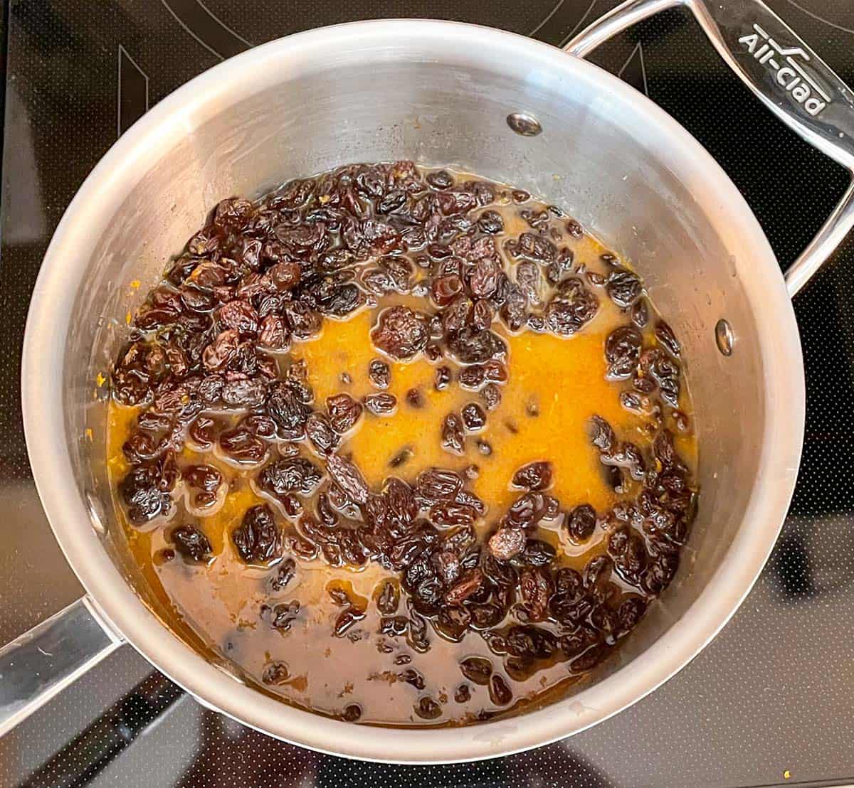 Cooking the raisin filling for the cookies with raisins, orange juice and zest along with rum extract.