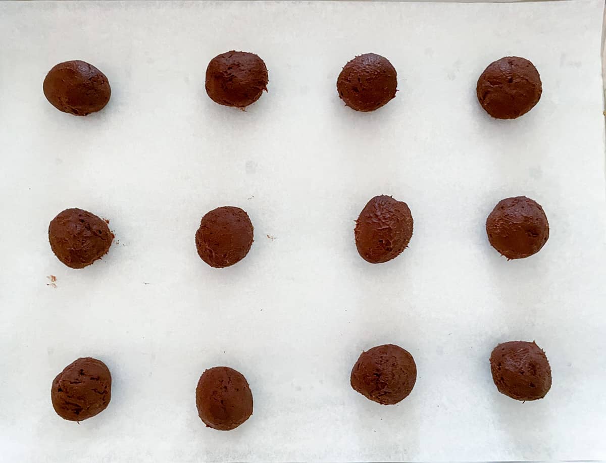 Chocolate espresso cookie dough formed into balls on a baking sheet pan.