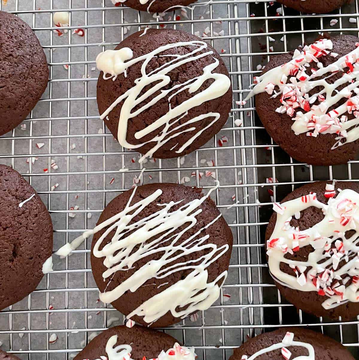 Espresso chocolate cookies on a rack that show no icing, then with white chocolate, and finally with white chocolate and crushed peppermint.