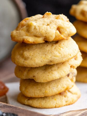 A stack of finished Apricot with orange and hazelnut cookies on a wooden board.