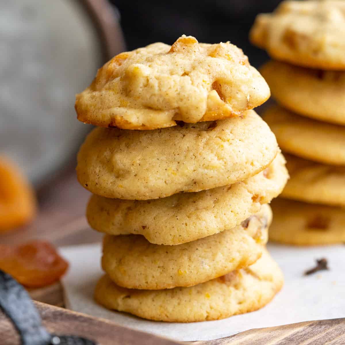 A stack of finished Apricot with orange and hazelnut cookies on a wooden board.